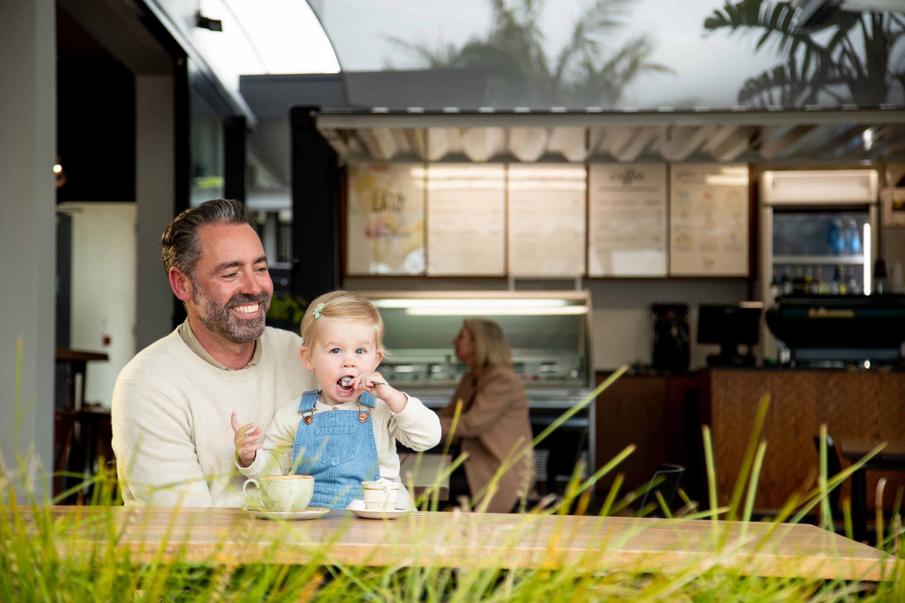 A father with his toddler at the Pt Chev Beach Cafe